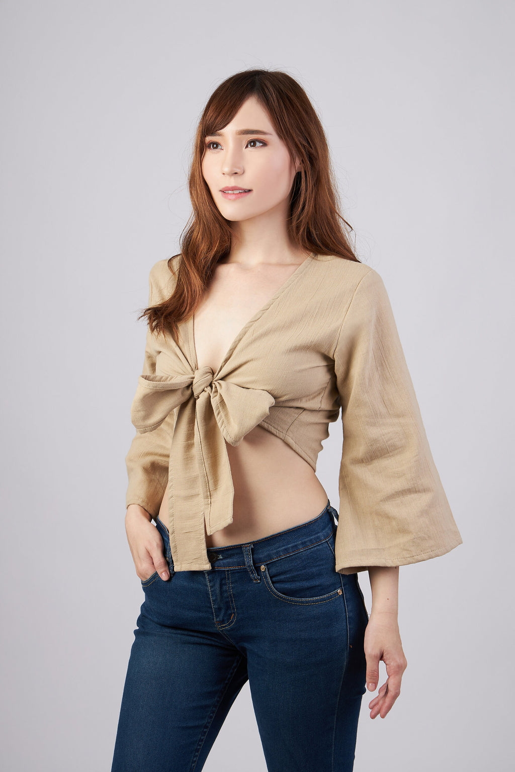Women's beige cotton wrap top worn with denim shorts