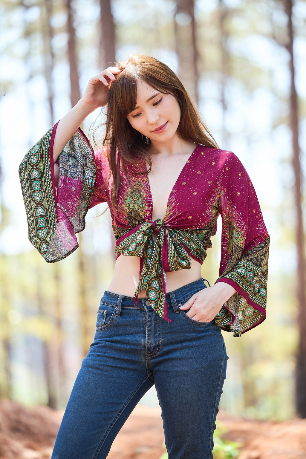 Boho bell sleeve wrap top in burgundy worn by model