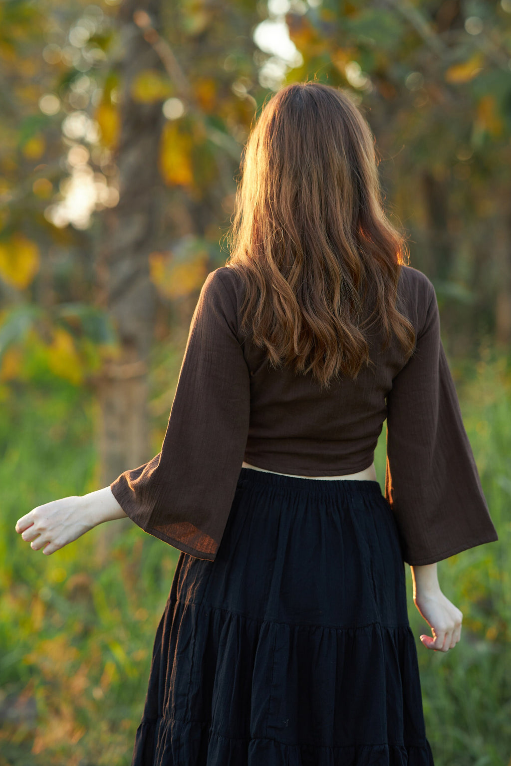 Women's brown cotton wrap top styled with jeans and denim shorts