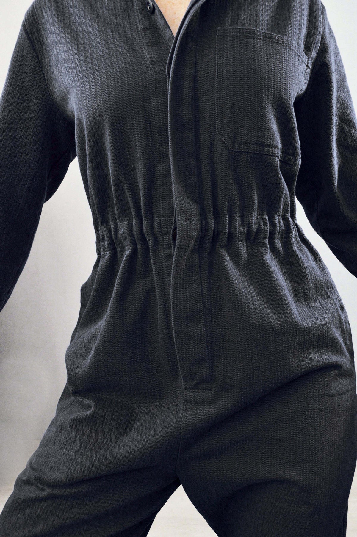 French workwear coveralls in black herringbone, styled with belt