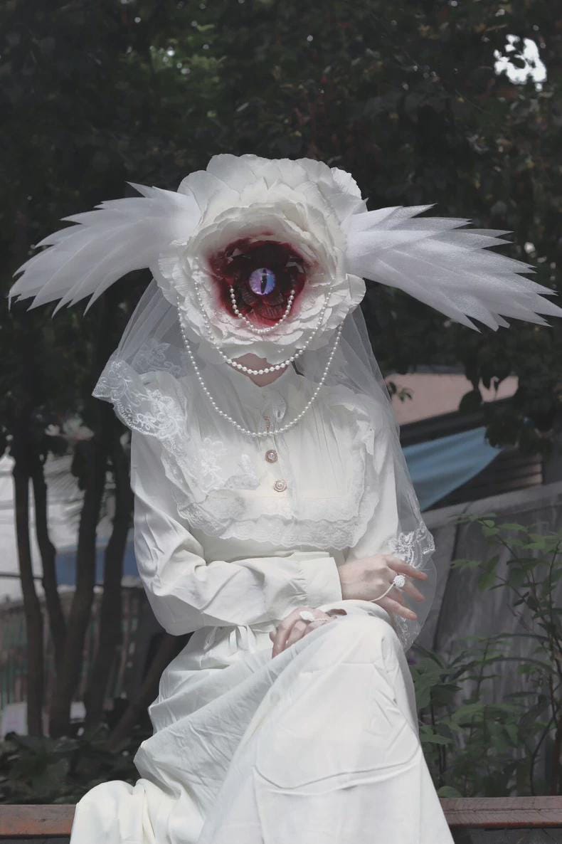 Surreal floral face cover with wing-like side details and soft veil